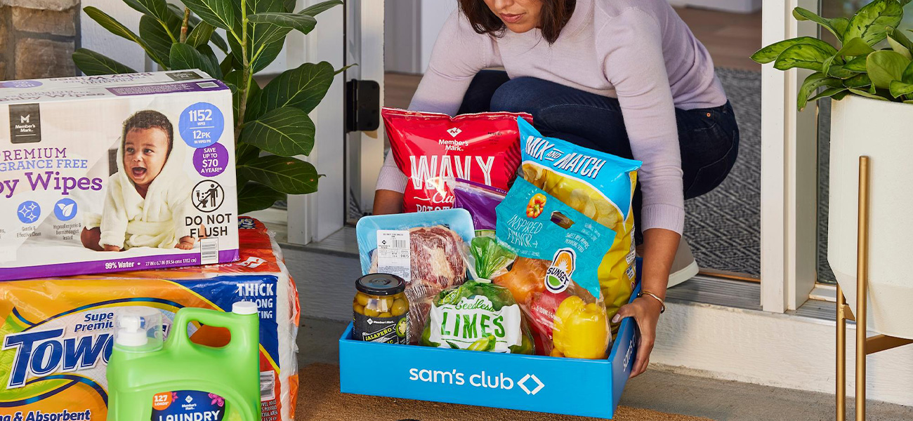 A Sam's Club member retrieves a delivery from her front door